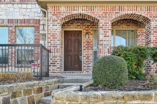 view of exterior entry featuring brick siding