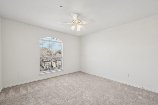 unfurnished room featuring light carpet, ceiling fan, and baseboards