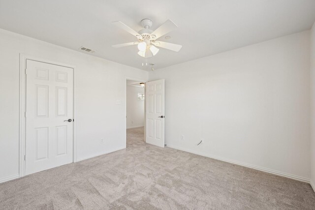 unfurnished bedroom with light carpet, baseboards, visible vents, and a ceiling fan