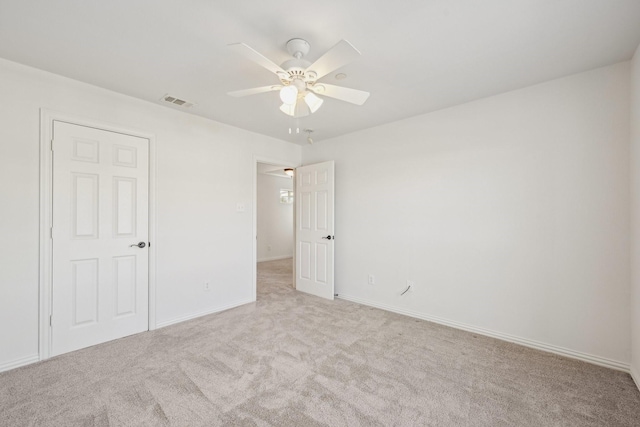 unfurnished bedroom featuring ceiling fan, carpet flooring, baseboards, and visible vents