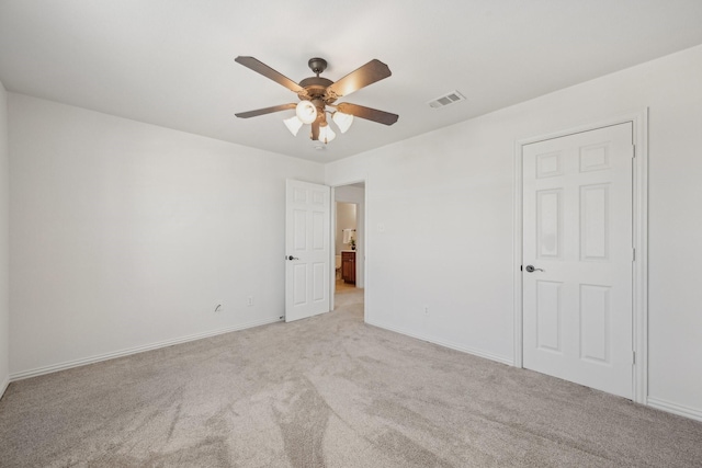 unfurnished bedroom featuring visible vents, baseboards, ceiling fan, and light colored carpet