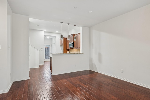 unfurnished living room featuring dark wood-style flooring, baseboards, and recessed lighting