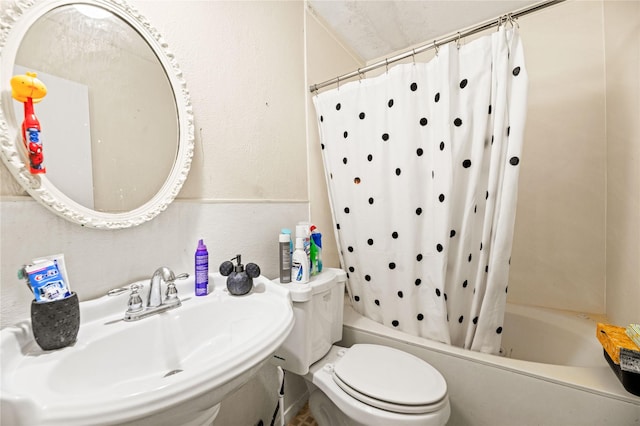 full bathroom featuring sink, shower / bathtub combination with curtain, and toilet