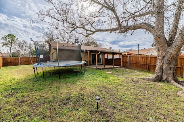 view of yard featuring a trampoline and a patio area