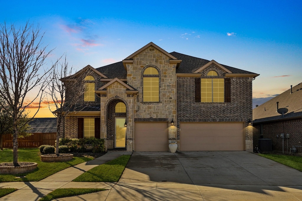 6844 San Luis Trl, Fort Worth, TX 76131 - french country style house featuring stone siding, central AC, brick siding, and a garage