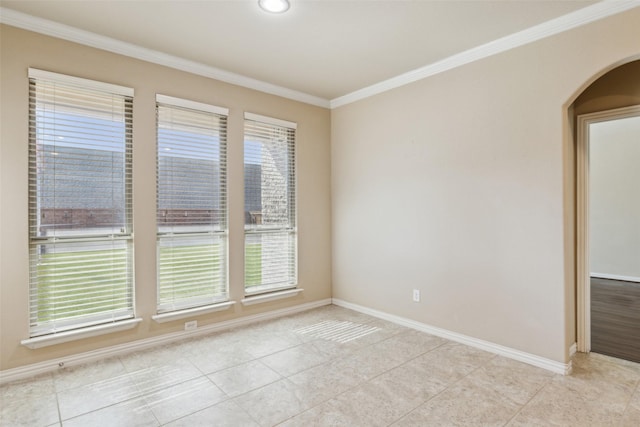 empty room featuring crown molding and light tile patterned flooring