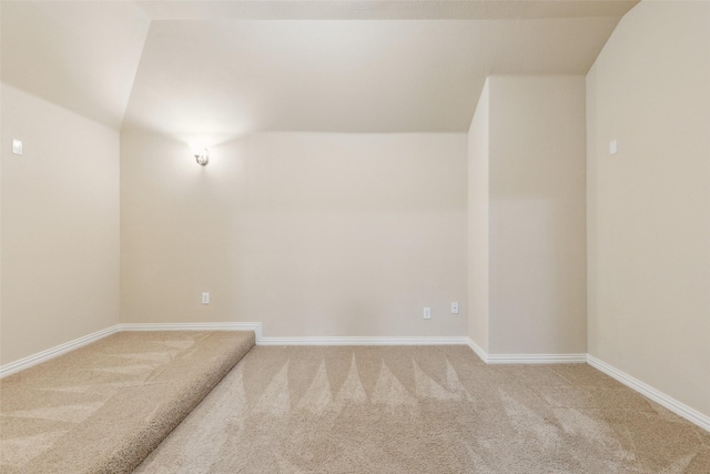 carpeted spare room featuring lofted ceiling