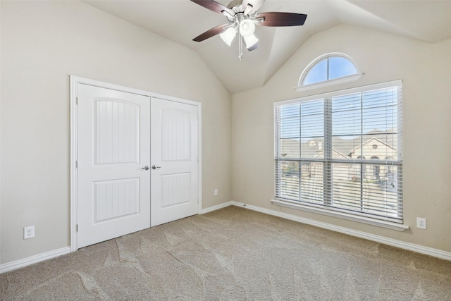 unfurnished bedroom featuring vaulted ceiling, light carpet, ceiling fan, and a closet