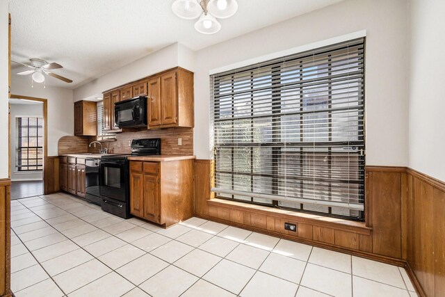 kitchen featuring pendant lighting, sink, black appliances, a textured ceiling, and light tile patterned flooring