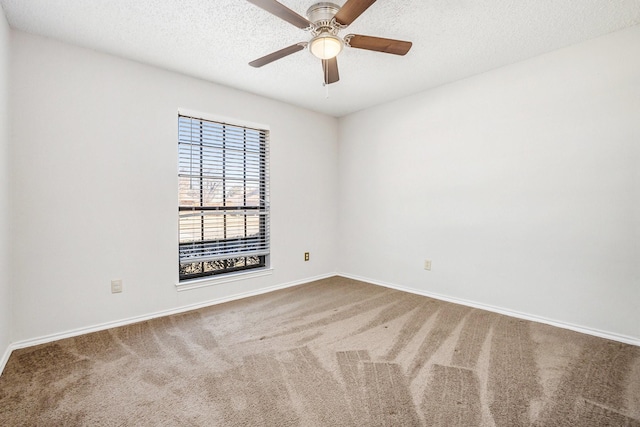 carpeted spare room with ceiling fan, baseboards, and a textured ceiling