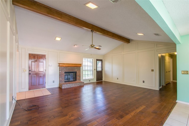 unfurnished living room with lofted ceiling with beams, ceiling fan, dark hardwood / wood-style floors, and a fireplace