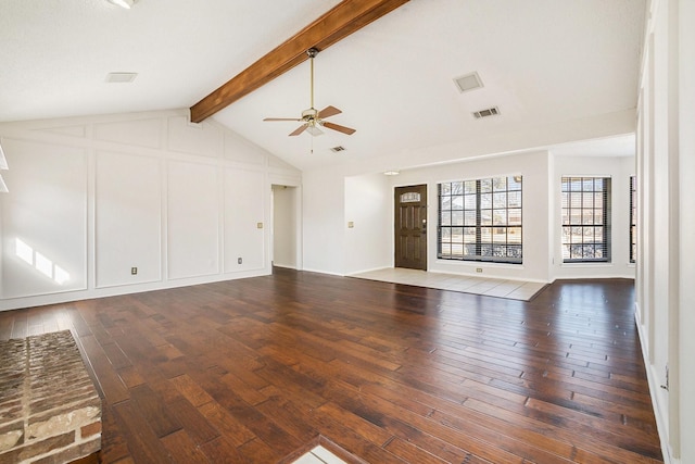 unfurnished living room with dark wood-style floors, visible vents, a decorative wall, lofted ceiling with beams, and ceiling fan