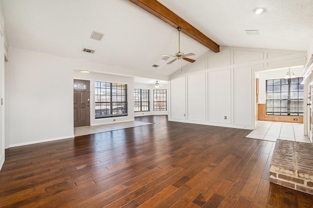 unfurnished living room featuring visible vents, wood finished floors, vaulted ceiling with beams, a decorative wall, and ceiling fan with notable chandelier