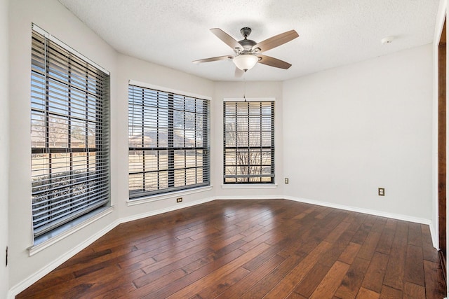 spare room featuring a textured ceiling, baseboards, hardwood / wood-style flooring, and a ceiling fan