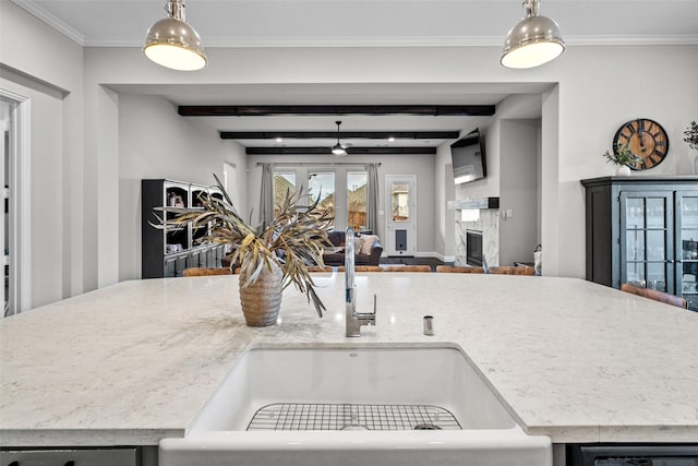 7400 E Fork Ln, Mckinney, TX 75071 - kitchen with open floor plan, a sink, a glass covered fireplace, beamed ceiling, and pendant lighting