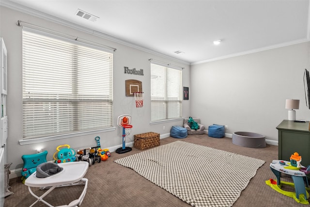 recreation room with visible vents, baseboards, ornamental molding, and carpet flooring