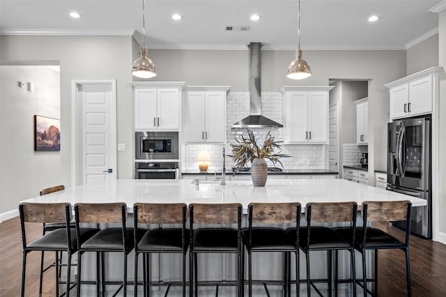 7400 E Fork Ln, Mckinney, TX 75071 - kitchen featuring appliances with stainless steel finishes, wall chimney range hood, dark wood-style flooring, a spacious island, and white cabinetry