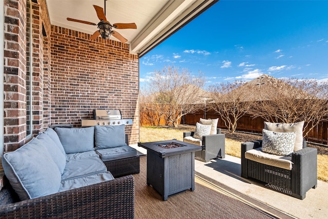 view of patio featuring ceiling fan and an outdoor living space with a fire pit