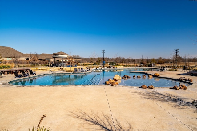 pool featuring a patio area and fence