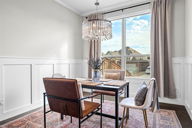 dining space featuring dark hardwood / wood-style flooring, ornamental molding, and a chandelier