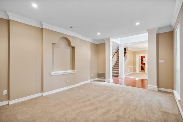 carpeted spare room featuring crown molding and decorative columns