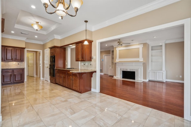 kitchen featuring a breakfast bar area, decorative light fixtures, kitchen peninsula, a high end fireplace, and black appliances