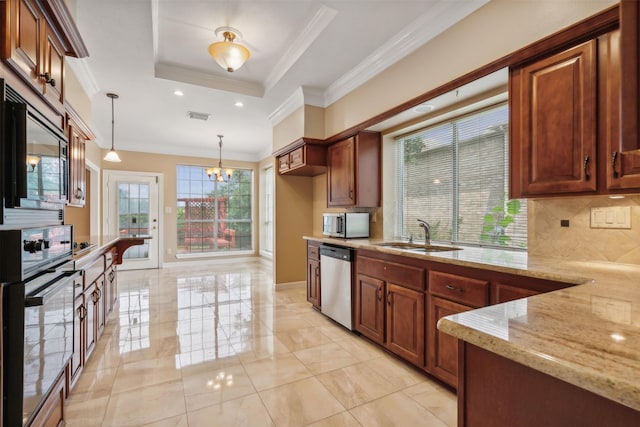 kitchen featuring sink, stainless steel appliances, a tray ceiling, light stone countertops, and decorative light fixtures