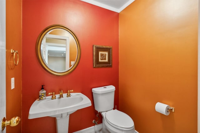 bathroom featuring crown molding and toilet