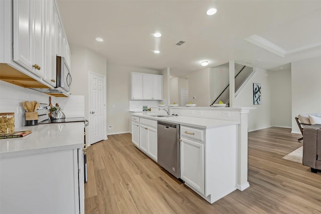 kitchen with white cabinetry, stainless steel appliances, sink, and light wood-type flooring