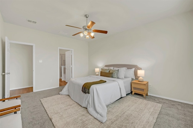 carpeted bedroom featuring ceiling fan and ensuite bathroom