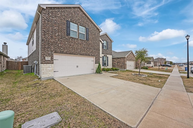 exterior space with cooling unit, a garage, and a front yard