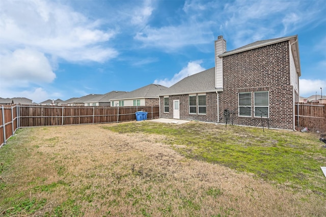 back of property featuring a lawn and a patio area