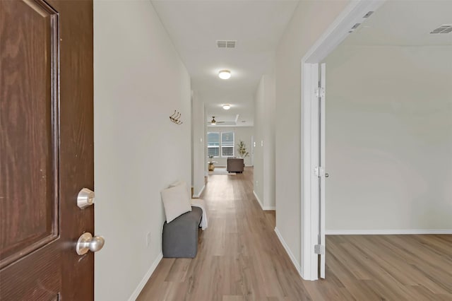 corridor with light hardwood / wood-style floors