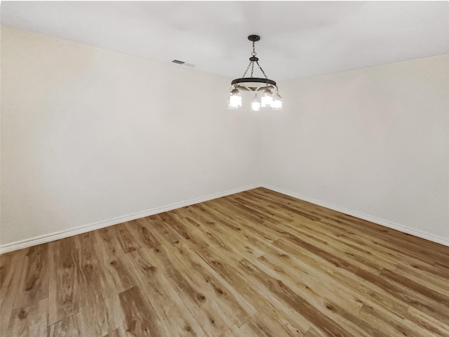 interior space featuring hardwood / wood-style flooring and an inviting chandelier