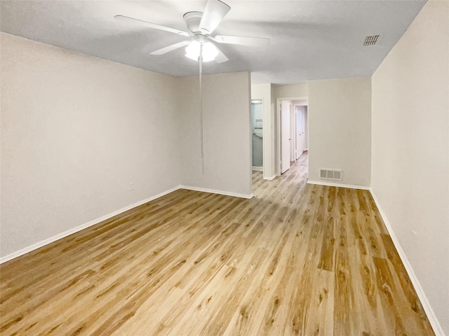 empty room with ceiling fan and light hardwood / wood-style floors