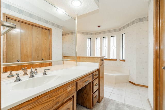 bathroom featuring vanity, tile patterned flooring, a textured ceiling, and a washtub