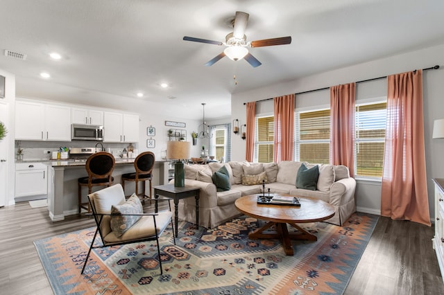 living room featuring ceiling fan and dark hardwood / wood-style flooring