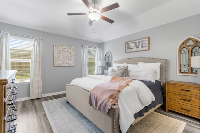 bedroom featuring multiple windows, ceiling fan, and dark hardwood / wood-style flooring