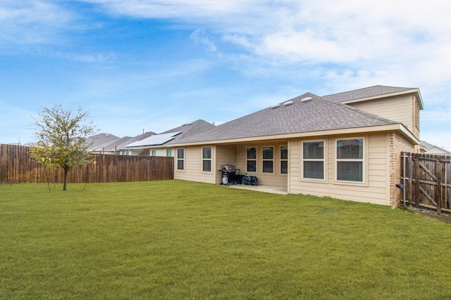 rear view of property with a yard and a patio area