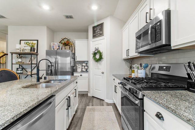 kitchen featuring appliances with stainless steel finishes, sink, and white cabinets