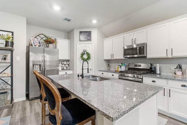 kitchen featuring a kitchen island with sink, sink, and stainless steel appliances