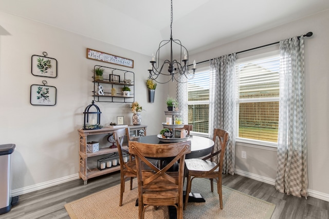 dining space featuring hardwood / wood-style floors and an inviting chandelier