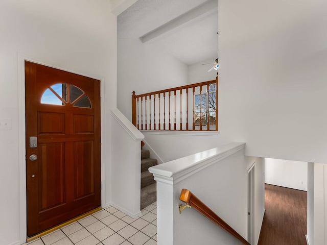 tiled foyer entrance featuring lofted ceiling with beams and ceiling fan