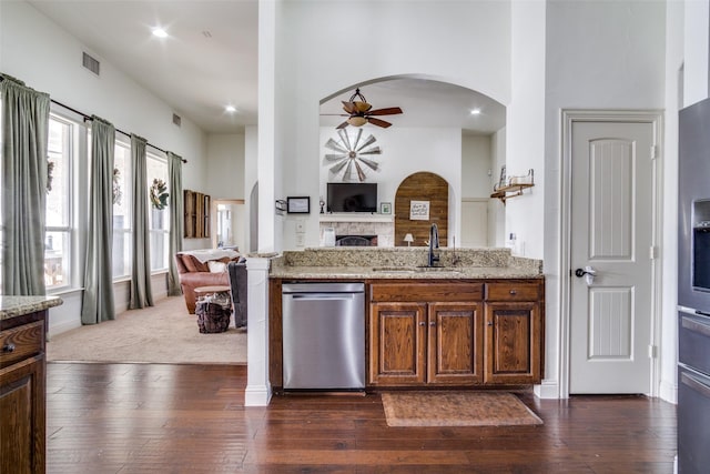 kitchen with dark hardwood / wood-style floors, sink, stainless steel dishwasher, ceiling fan, and light stone countertops