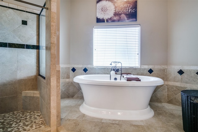 bathroom featuring independent shower and bath and tile walls