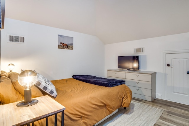 bedroom with lofted ceiling and light hardwood / wood-style flooring