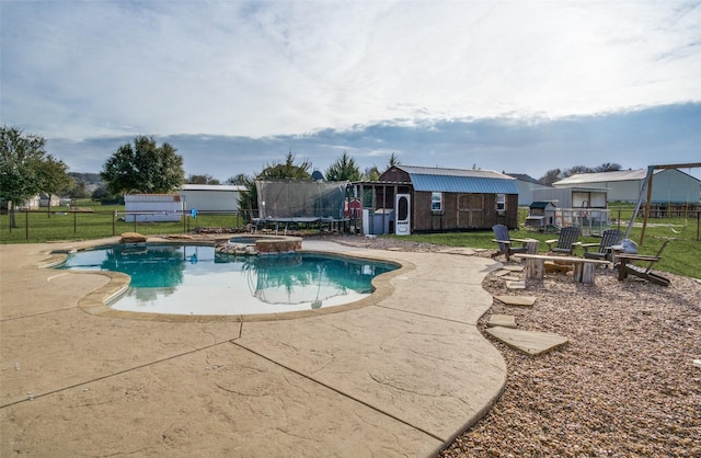 view of swimming pool featuring a trampoline, an outdoor fire pit, an outdoor structure, and a patio