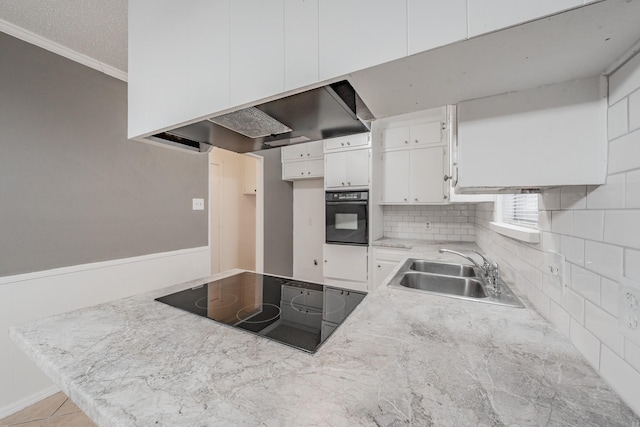 kitchen with sink, tasteful backsplash, ventilation hood, black appliances, and white cabinets