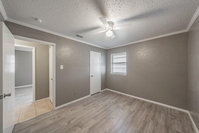 unfurnished bedroom with ceiling fan, light hardwood / wood-style floors, crown molding, a textured ceiling, and a closet