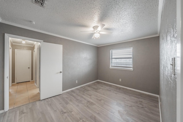 empty room with ceiling fan, ornamental molding, light hardwood / wood-style flooring, and a textured ceiling